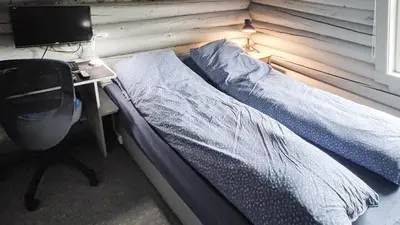 a bedroom with a bed and a desk with a computer at Hytta Idyll in Dagali