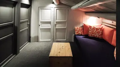 a room with two beds and a door and a bench at Hytta Idyll in Dagali