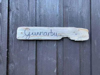 a wooden sign hanging on a wooden fence at Newly renovated cabin near Ål city center, mountains & ski resort in Liagardane