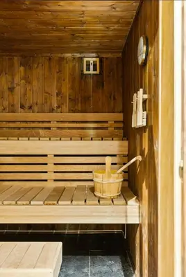 a wooden sauna with a wooden basket in it at 70S Architectural Cabin With Views In Hemsedal in Hemsedal