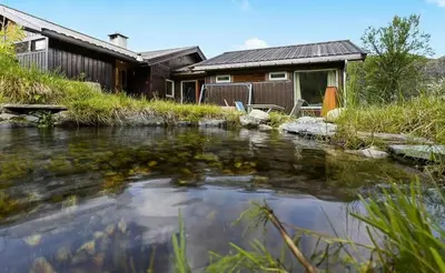 a house with a pond in front of it at 70S Architectural Cabin With Views In Hemsedal in Hemsedal