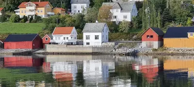 a group of houses on a hill next to a body of water at Sjøhuset Sjøholt in Sjøholt