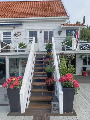 a stairway with potted plants in front of a house at Sjøhuset Sjøholt in Sjøholt