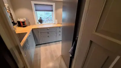 a kitchen with a sink and a window at Sjøhuset Sjøholt in Sjøholt