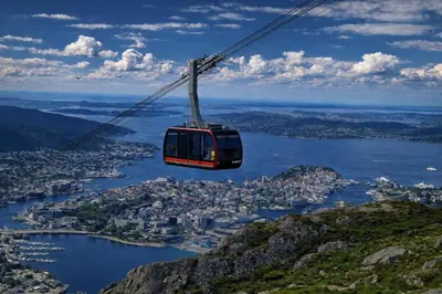 a gondola flying over a city and a body of water at Bergen City Center Apartment in Bergen