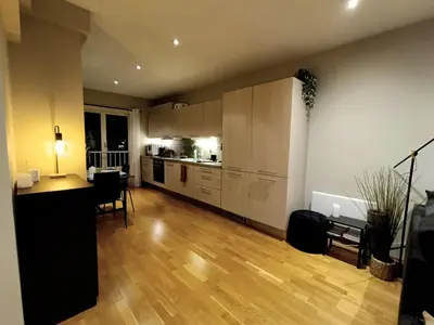 a kitchen and living room with a table and chairs at Bergen City Center Apartment in Bergen