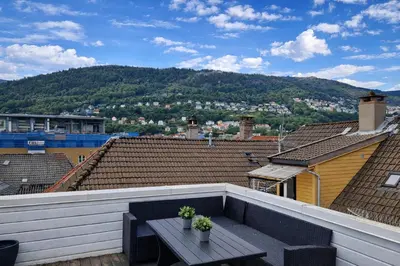 a balcony with a bench on the roof of a building at Bergen City Center Apartment in Bergen