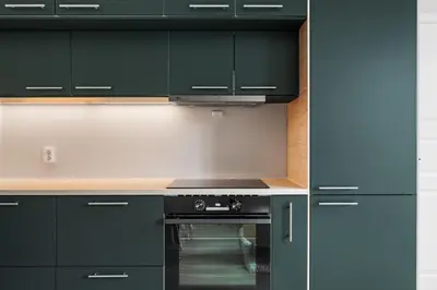 a kitchen with green cabinets and a stove at Bergen Beds Apartments I Nordic Retreat in Bergen
