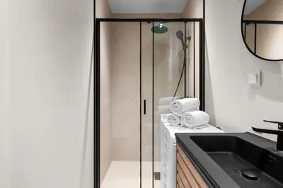 a bathroom with a glass shower and a sink at Bergen Beds Apartments I Nordic Retreat in Bergen