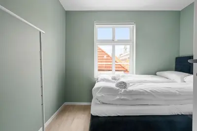 a bedroom with two beds and a window at Bergen Beds Apartments I Nordic Retreat in Bergen