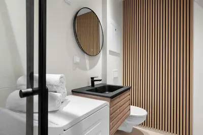 a bathroom with a black sink and a toilet at Bergen Beds Apartments I Nordic Retreat in Bergen
