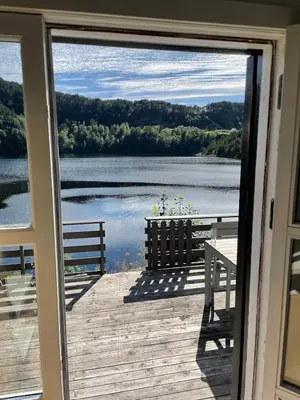a view of a lake from a house door at Beautiful Cottage by the Sea in Tysse