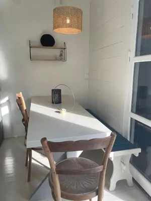 a white table with two chairs and a laptop on it at Beautiful Cottage by the Sea in Tysse