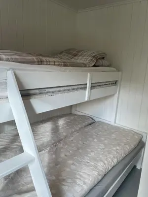 two bunk beds in a room with a bed at Beautiful Cottage by the Sea in Tysse