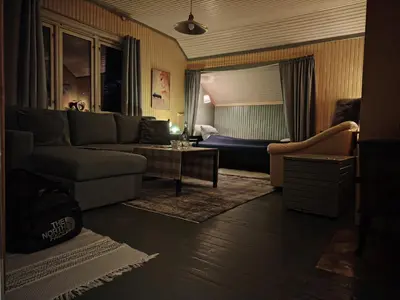 a living room with a couch and a bed at Landgård Feriehus in Trysil