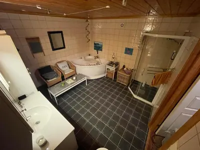 a bathroom with a tub and a sink at Landgård Feriehus in Trysil