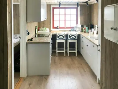 a kitchen with white cabinets and a wooden floor at Traditional Cabin In Nøsterbølia in Uvdal