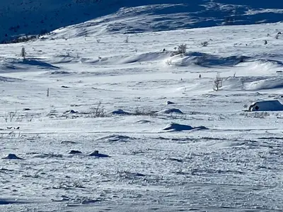 a snow covered slope with a mountain in the background at Traditional Cabin In Nøsterbølia in Uvdal