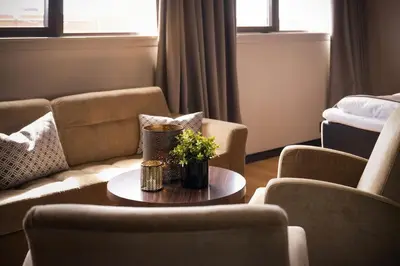 a living room with couches and a table with flowers at Ågotnes Hotell in Ågotnes