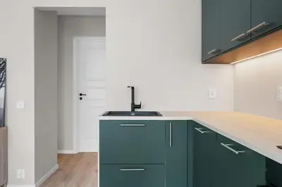 a kitchen with green cabinets and a sink at Bergen Beds Apartments I Urban Escape in Bergen