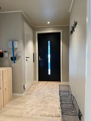 a hallway with a black door in a house at Stor enebolig med stor inngjerdet hage og lekestativ! Perfekt for barnefamilier in Jevnaker