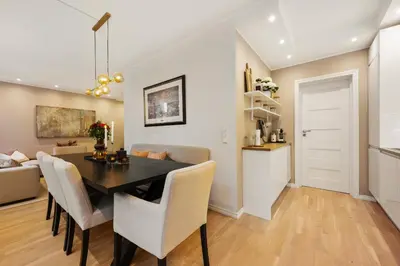 a dining room and living room with a table and chairs at Luxury Summer Apartment with Balcony Near Bryggen in Bergen