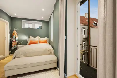 a bedroom with a bed and a balcony at Luxury Summer Apartment with Balcony Near Bryggen in Bergen