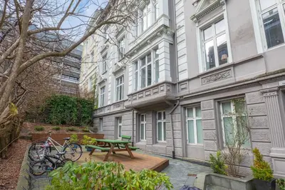a bench and a picnic table in front of a building at Roomsly Apartments - Prime Location and Modern Comfort in Bergen