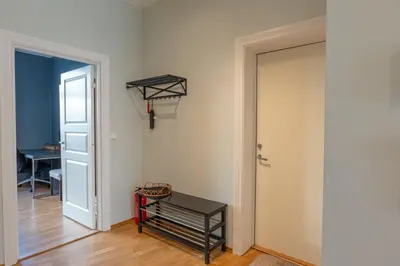 a hallway with a door and a bench and a table at Roomsly Apartments - Prime Location and Modern Comfort in Bergen