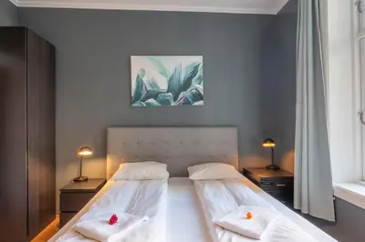 a bedroom with a bed with two pillows on it at Roomsly Apartments - Prime Location and Modern Comfort in Bergen