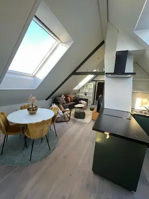 a attic living room with a table and chairs at Nord Apartments in Trondheim