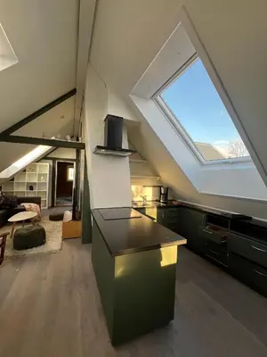 an attic kitchen with a skylight and a living room at Nord Apartments in Trondheim