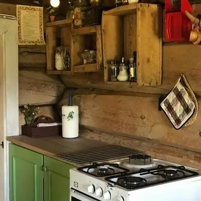 a kitchen with a stove and a green cabinet at Charming lodge from 1888 in Sel
