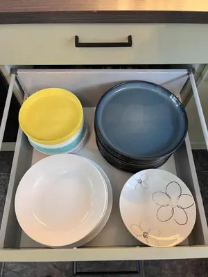 four plates and bowls in a drawer at Idyllic houses in quiet surroundings in Vossevangen