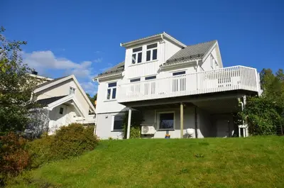 a white house with a balcony on top of a yard at House with all amenities for rent in Steinkjer