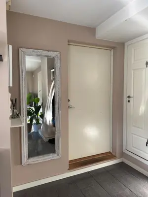 a mirror on a wall next to a door at Cozy apartment near city center and the mountains in Bergen