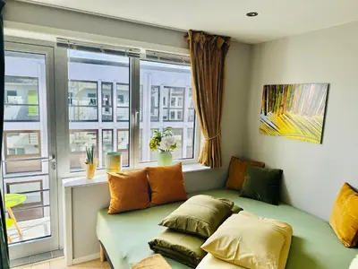 a living room with a couch and a window at Stylish free parking Studio central with balcony in Ålesund