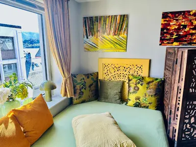 a living room with a couch and a window at Stylish free parking Studio central with balcony in Ålesund