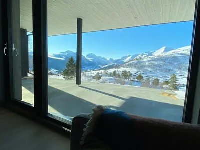 a room with a large window looking out at a snowy mountain at The Panoramic Chalet in Stranda
