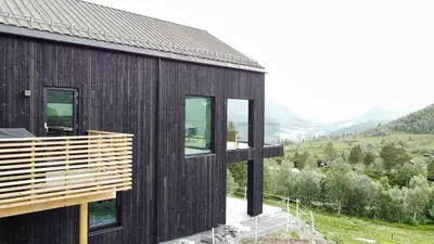 a black house with a view of a mountain at The Panoramic Chalet in Stranda