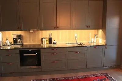 a kitchen with gray cabinets and a sink at Hafjelltoppen-New apartment with a beautiful view and high standard in Hafjell