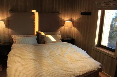 a bedroom with a bed with two lamps and a window at Hafjelltoppen-New apartment with a beautiful view and high standard in Hafjell