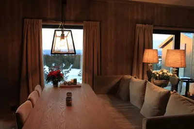a living room with a couch and a table at Hafjelltoppen-New apartment with a beautiful view and high standard in Hafjell