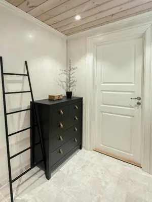 a room with a dresser and a white door at Modern Apartment At Strandafjellet Ski Resort in Stranda