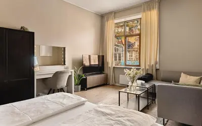 a bedroom with a bed and a living room at Fløyen Suites - Private Rooms with the best location in Bergen in Bergen