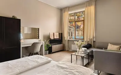 a bedroom with a bed and a living room at Fløyen Suites - Private Rooms with the best location in Bergen in Bergen