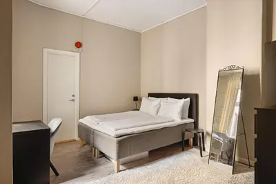 a bedroom with a bed and a mirror in it at Fløyen Suites - Private Rooms with the best location in Bergen in Bergen