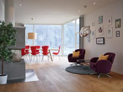 a living room with red chairs and a table at Villa Fjord View in Stranda
