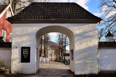 a white building with an arch in a street at Modern apartment by the sea in Bergen