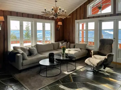 a living room with a couch and a table and chairs at Modern Cabin With Ski In-Out In Hafjell in Øyer